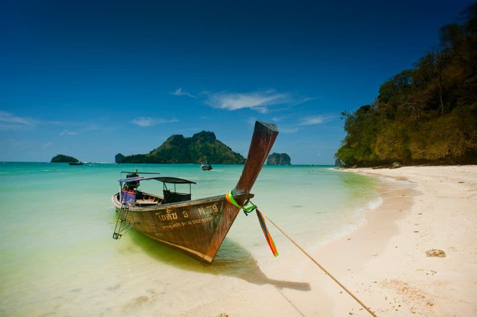 Traditional longtail boat on Ao Nang's turquoise beach in Krabi, Thailand